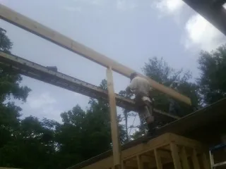 Carpenter setting a ridge beam over a new addition frame — Ice Dam Removal by Roofing Brothers in Saddle River