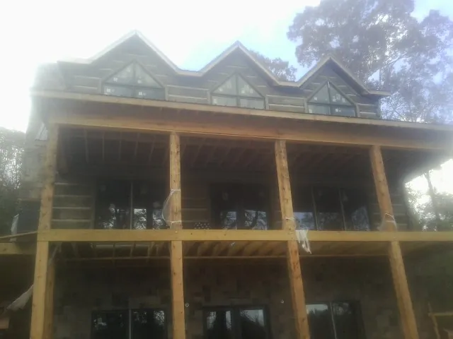 Dormers and porch framing on a large log home under construction — Roof Coating work by our crew in Saddle River