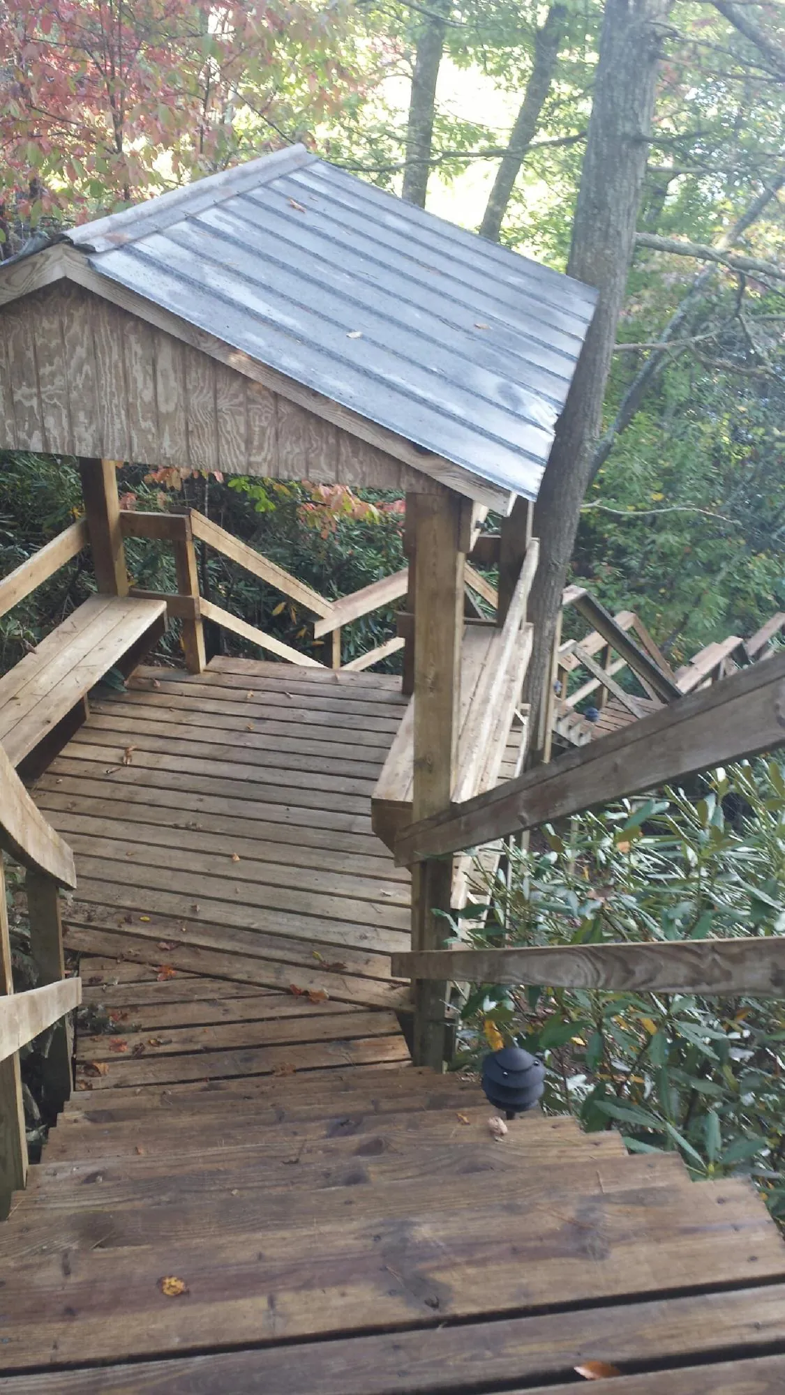 Metal roofed shelter over wooden steps on a wooded walkway — Skylight Repair & Installation work by our crew in Saddle River