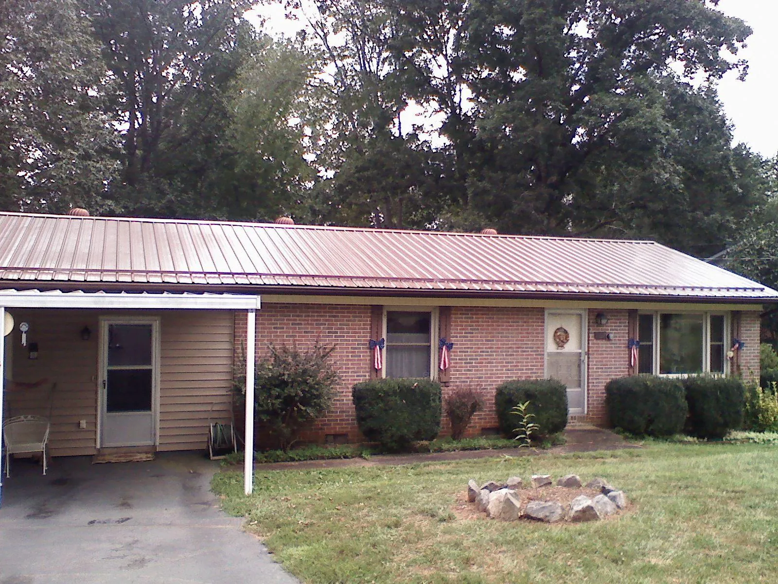 Bronze metal roof and carport on a brick ranch home — Roof Repair work by our crew in Saddle River